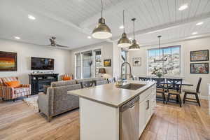 Kitchen featuring white cabinetry, decorative light fixtures, recessed lighting, stainless steel dishwasher, and open floor plan