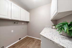Washroom with light wood-style floors and cabinet space