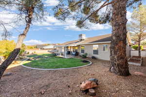 Rear view of property with a patio area, a fenced backyard, stucco siding, a tiled roof, and a chimney