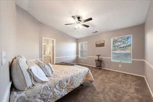Bedroom featuring vaulted ceiling, carpet, ceiling fan, and ensuite bathroom