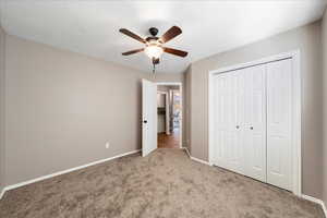 Unfurnished bedroom with a closet, carpet floors, and ceiling fan
