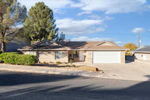 Ranch-style home with brick and stucco siding, concrete driveway, and a garage