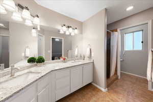 Full bath with double vanity and a shower with curtain
