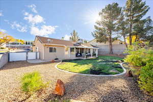 Back of property with a patio area, a fenced backyard, stucco siding, and a gate