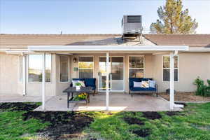 Rear view of house with an outdoor living space, stucco siding, a tile roof, a patio area, and a yard
