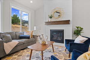 Living room with a large fireplace and vaulted ceiling