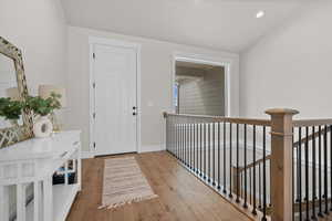 Foyer entrance featuring light wood finished floors and lofted ceiling