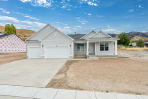 View of front facade with board and batten siding, a porch, a mountain view, driveway, and a garage