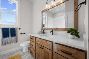 Full bathroom featuring vanity and light marble finish flooring