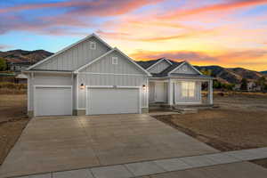 View of front of property with board and batten siding, a mountain view, a garage, and a porch