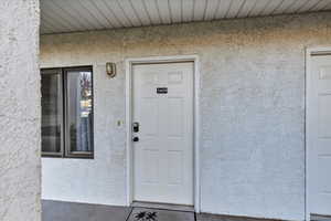 Doorway to property with stucco siding