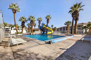 Community pool featuring a water slide and a patio