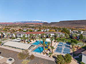 Aerial perspective of suburban area featuring a pool and a mountain backdrop