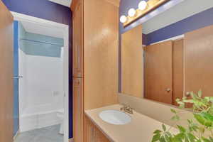 Full bathroom featuring vanity, shower / bath combo, and light tile patterned flooring