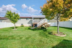 Rear view of house featuring a fenced backyard, a pergola, a wooden deck, and stairs