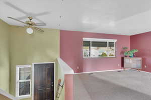 Carpeted empty room with ceiling fan and baseboards