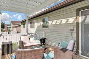 Wooden terrace with an outdoor living space and a pergola