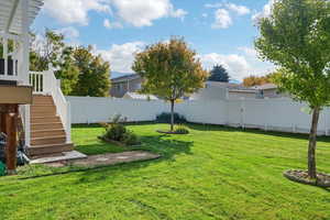 Fenced backyard featuring stairs and a deck