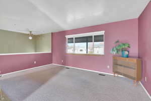 Carpeted empty room featuring ceiling fan and baseboards