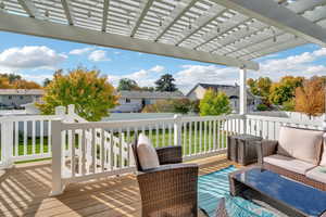 Wooden deck with a pergola, a fenced backyard, and a residential view