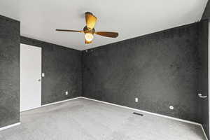 Empty room featuring light carpet and a ceiling fan