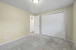 Unfurnished bedroom featuring a closet and carpet