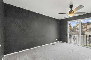 Carpeted empty room with a ceiling fan and baseboards