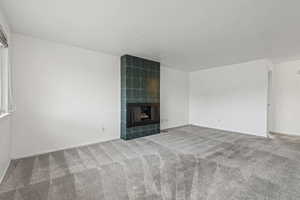 Unfurnished living room with carpet floors and a fireplace