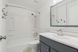 Full bath featuring shower / tub combination, vanity, and light tile patterned floors