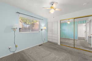 Unfurnished bedroom with carpet flooring, ceiling fan, and a closet