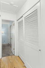 Hall featuring light wood-type flooring and a textured ceiling