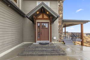 Property entrance featuring stone siding and a porch