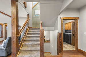Stairs featuring washer and dryer and parquet floors