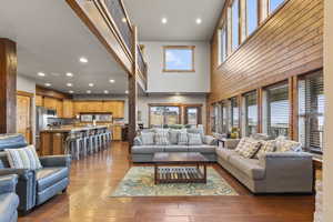 Living area with recessed lighting, light wood finished floors, and a high ceiling
