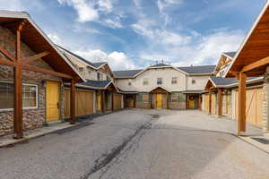 View of front of home with stone siding, a garage, and asphalt driveway