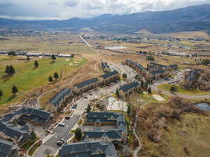 Aerial view of property's location featuring a water and mountain view and nearby suburban area