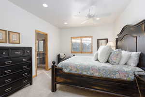 Bedroom with light carpet, ceiling fan, ensuite bathroom, and recessed lighting