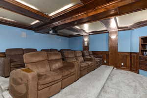 Home theater with wainscoting, carpet flooring, a textured ceiling, coffered ceiling, and ornamental molding