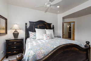 Carpeted bedroom with a ceiling fan and baseboards