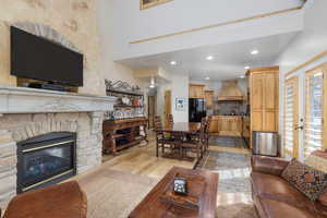 Living room featuring a stone fireplace, light wood-type flooring, and recessed lighting
