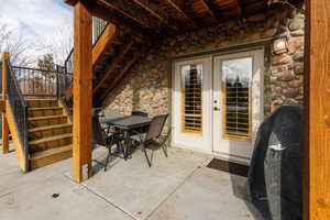 View of patio featuring stairway, outdoor dining space, grilling area, a deck, and french doors