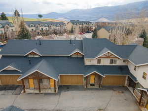 View of front of home featuring a mountain view, stone siding, a residential view, and a porch