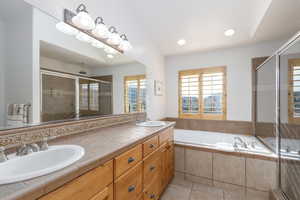 Bathroom featuring double vanity, a shower stall, a garden tub, light tile patterned floors, and recessed lighting