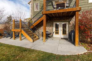 Back of house featuring stairway, a patio area, and stone siding