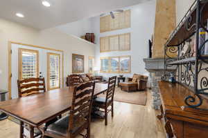 Dining room featuring light wood finished floors, french doors, recessed lighting, healthy amount of natural light, and a high ceiling