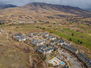 Aerial view of property and surrounding area with nearby suburban area and a mountain backdrop