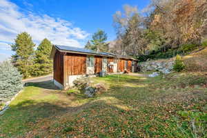 Back of house featuring solar panels and a yard