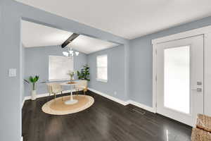 Sitting room with dark wood finished floors and a chandelier