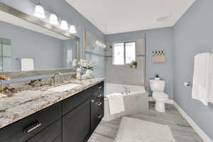 Full bathroom with vanity and baseboards