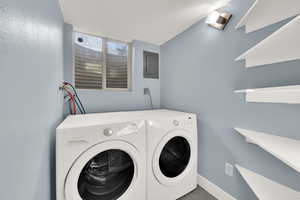 Laundry room with washing machine and dryer and electric panel